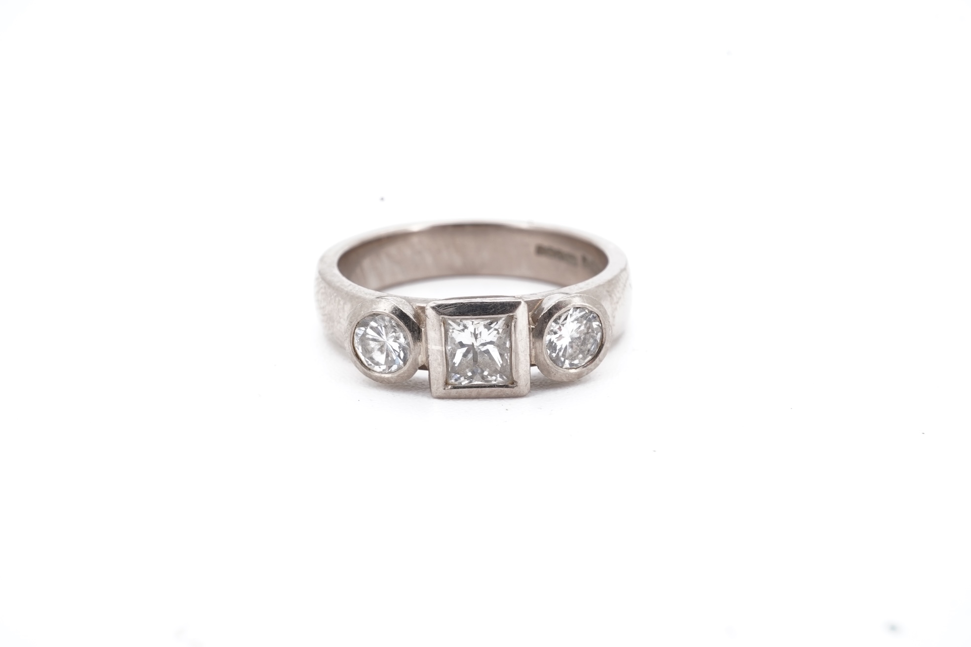 A modern 18ct white gold and three stone diamond ring, set with single square cut diamond and two round cut diamonds, size K, gross weight 5.8 grams.